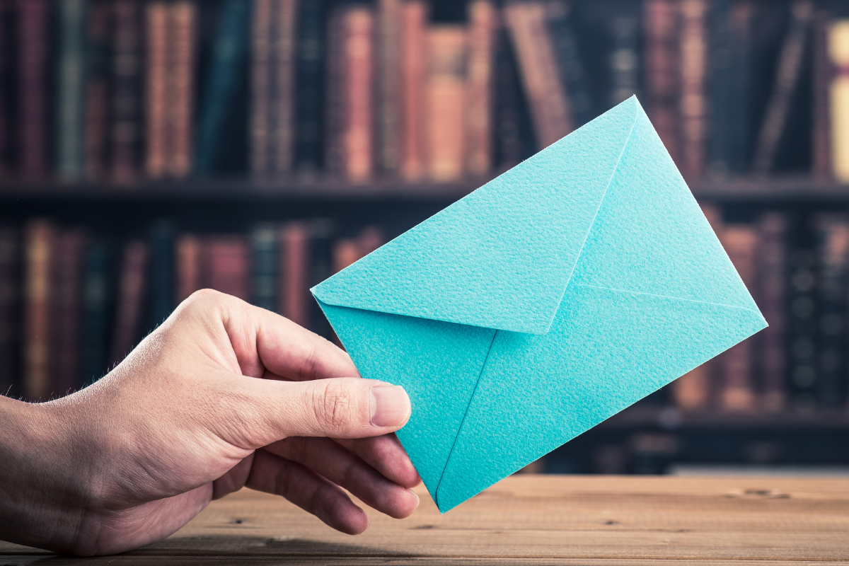 Hand passing blue tip envelope
