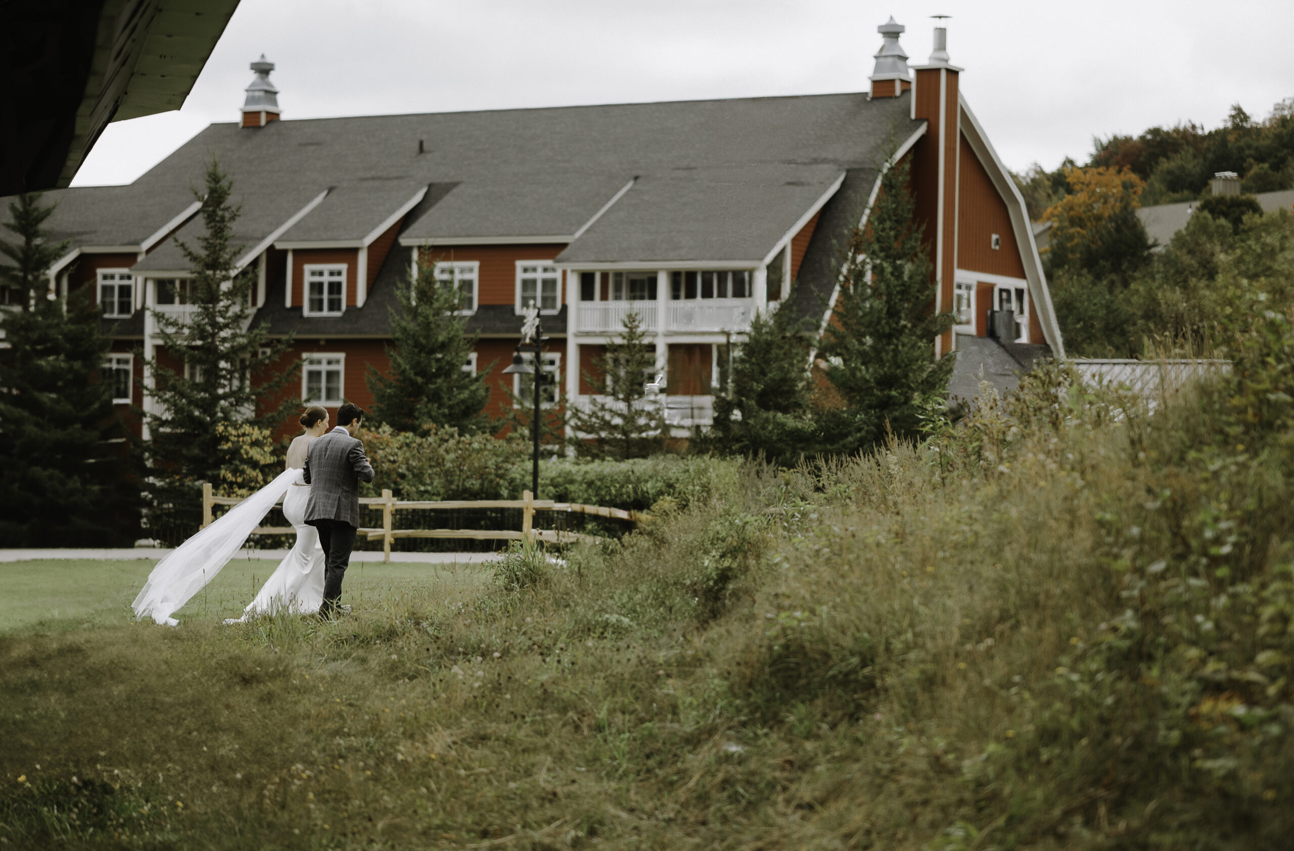 A newlywed couple walking to the red barns at Sugarbush Resort